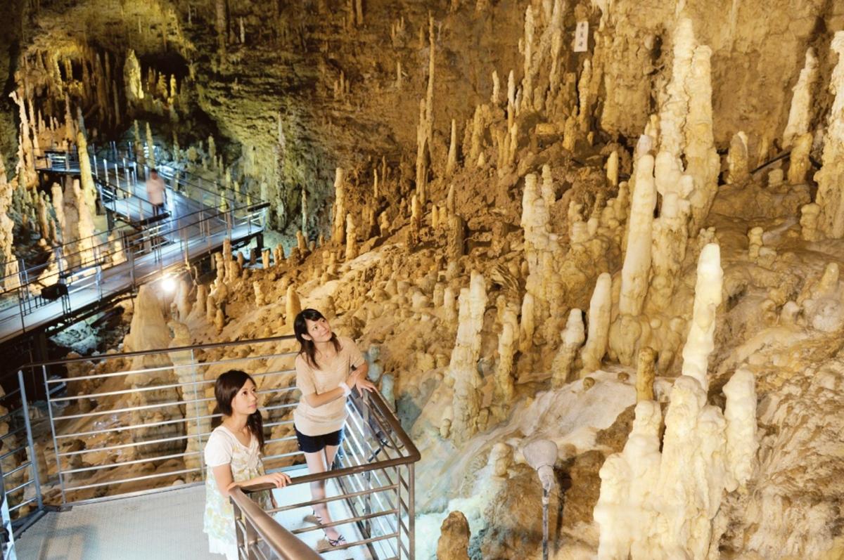 two women in a cave with a rock wall