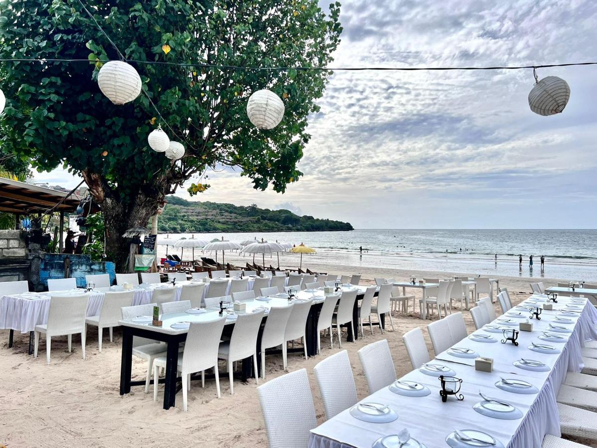 a row of tables and chairs on the beach