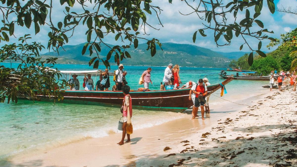 sekelompok orang di atas perahu di pantai