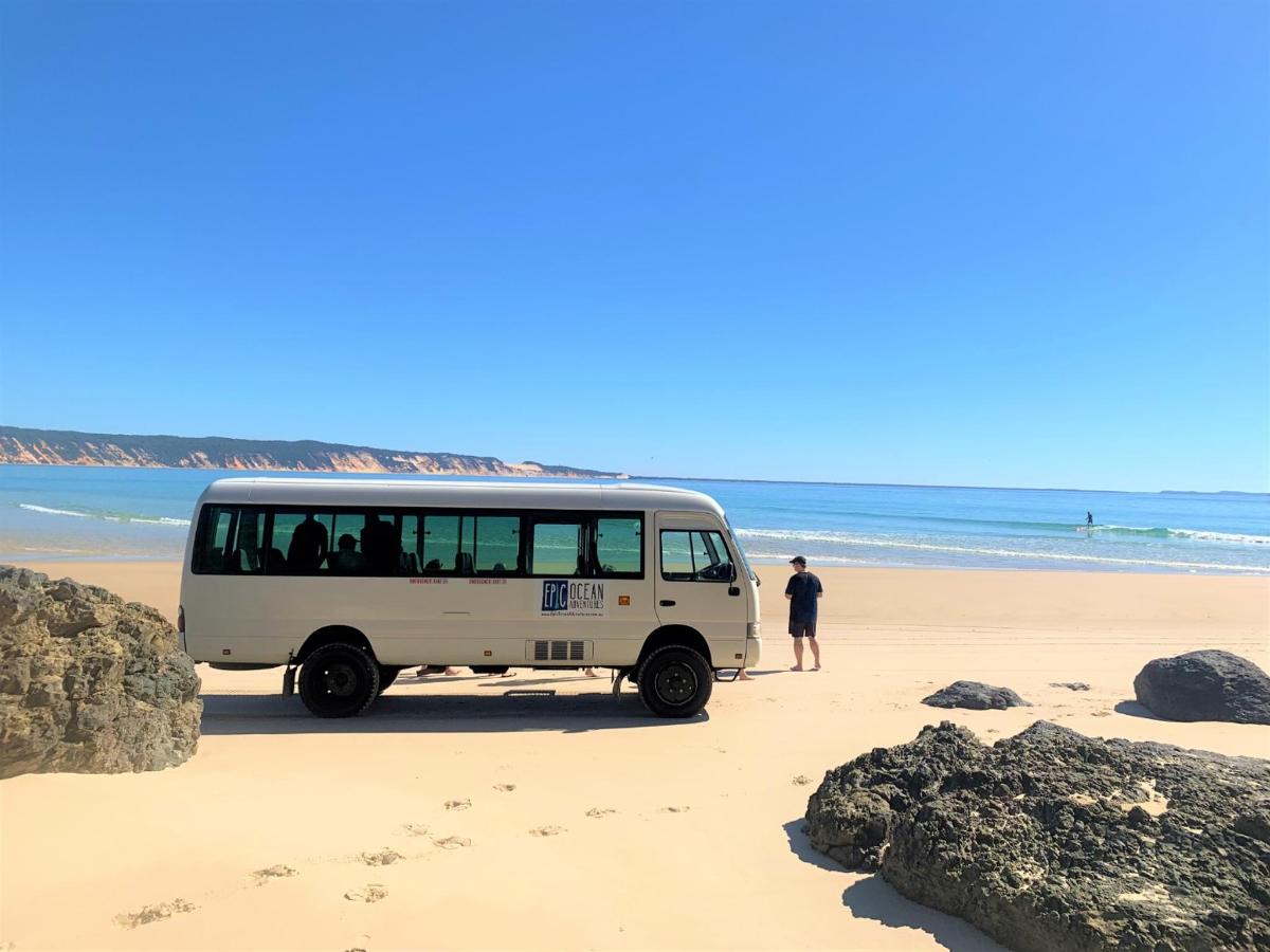 a white van parked on the beach with a man