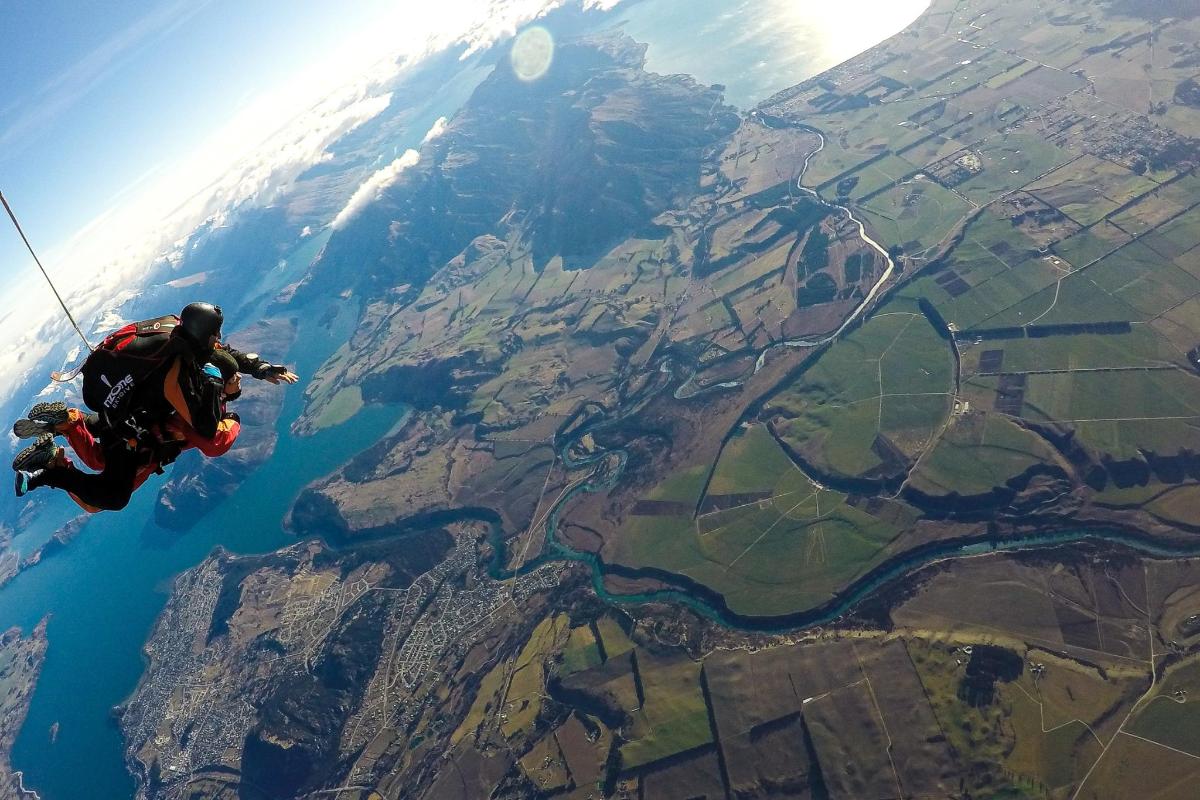 a man flying through the air while riding a parachute
