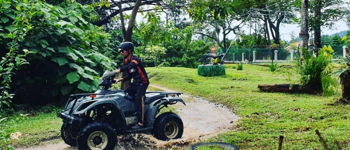 un uomo in sella a un quad su un sentiero sterrato