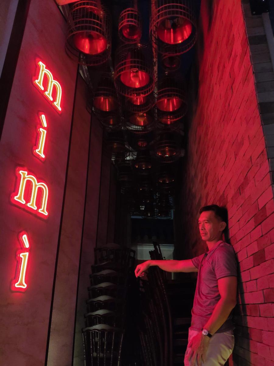 a man standing next to a wall with red lights