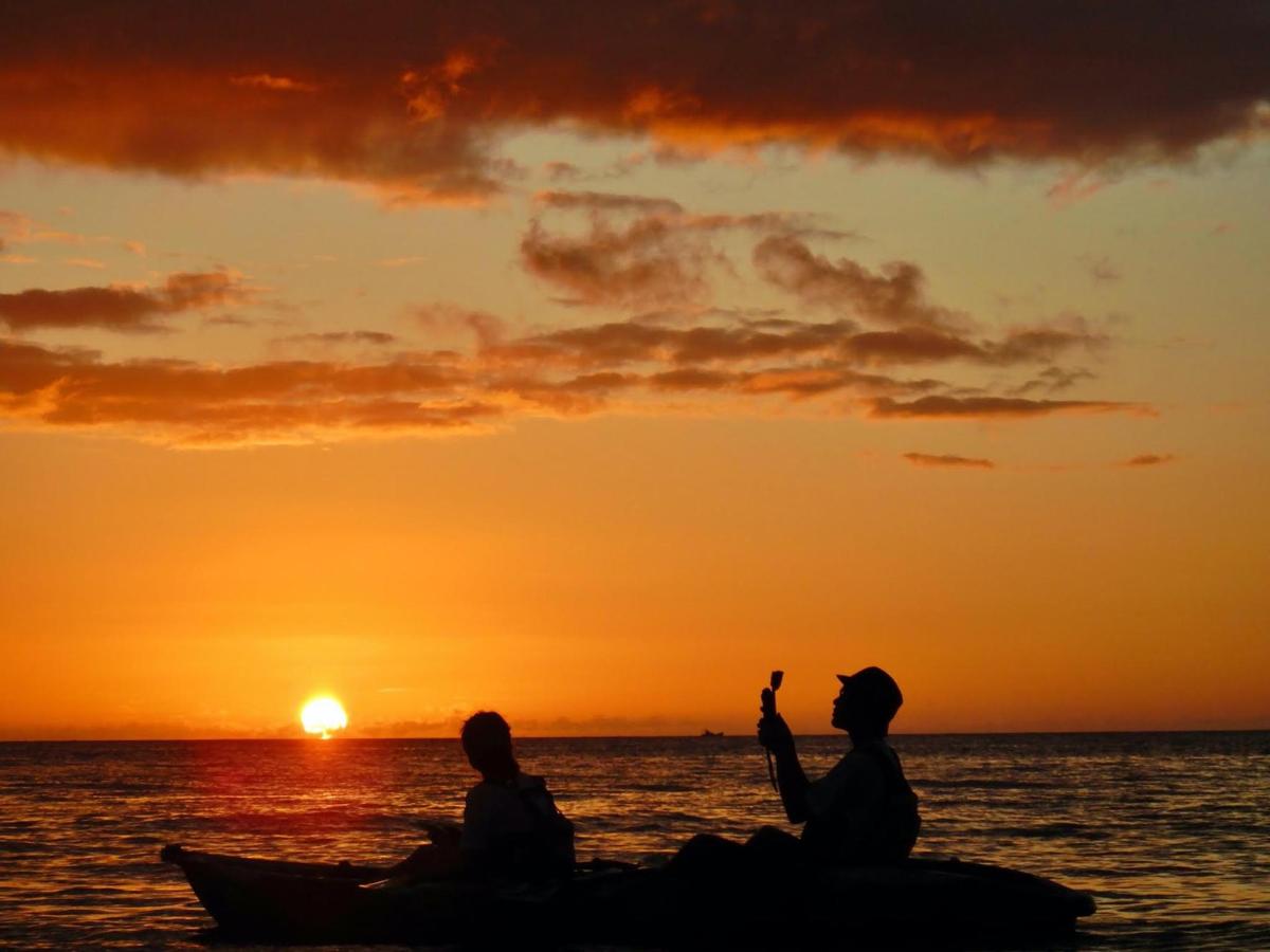 two people sitting on a boat watching the sunset