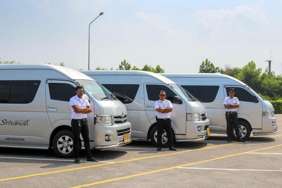three men standing in front of a row of vans