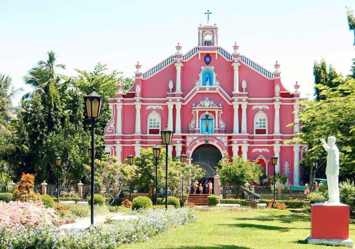 a pink building with a statue in front of it