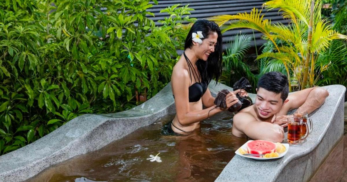 una donna che scatta una foto a un uomo in acqua