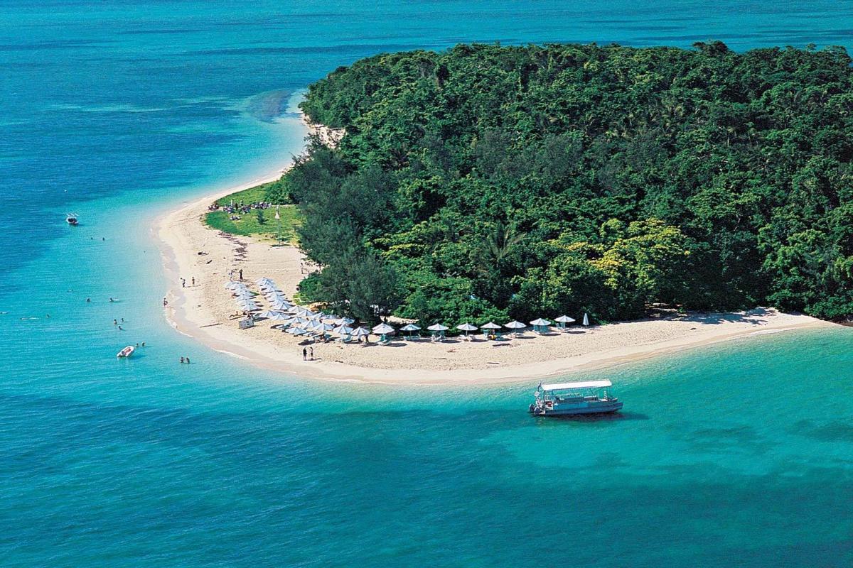 an island with umbrellas and a boat in the water