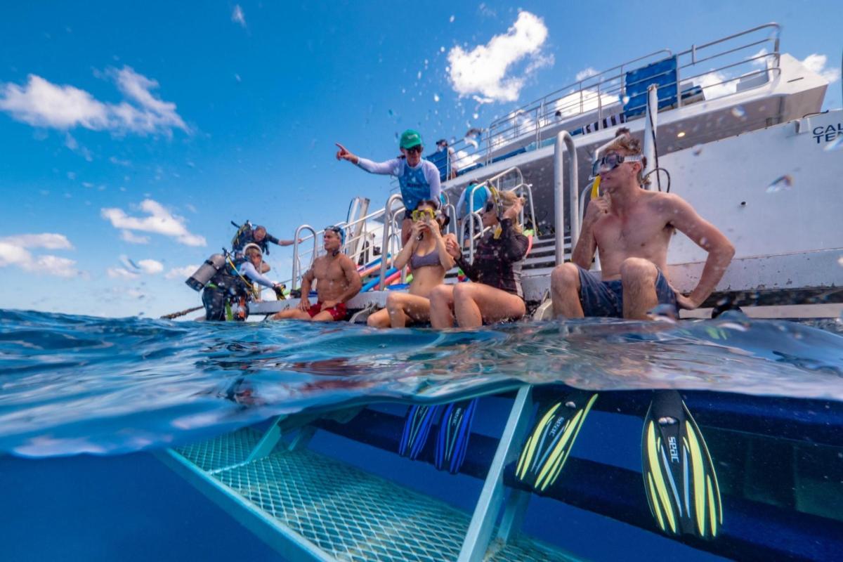 a group of people sitting on a boat in the ocean