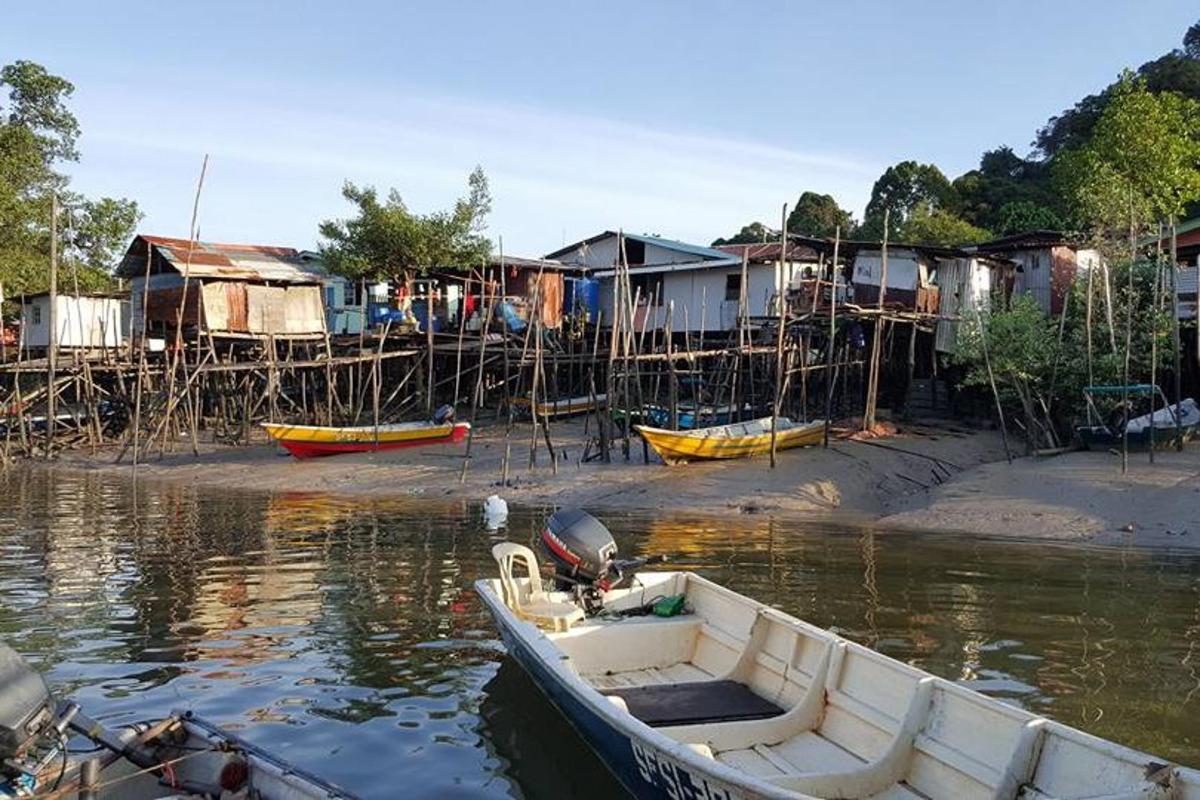 a boat in the water next to a group of houses