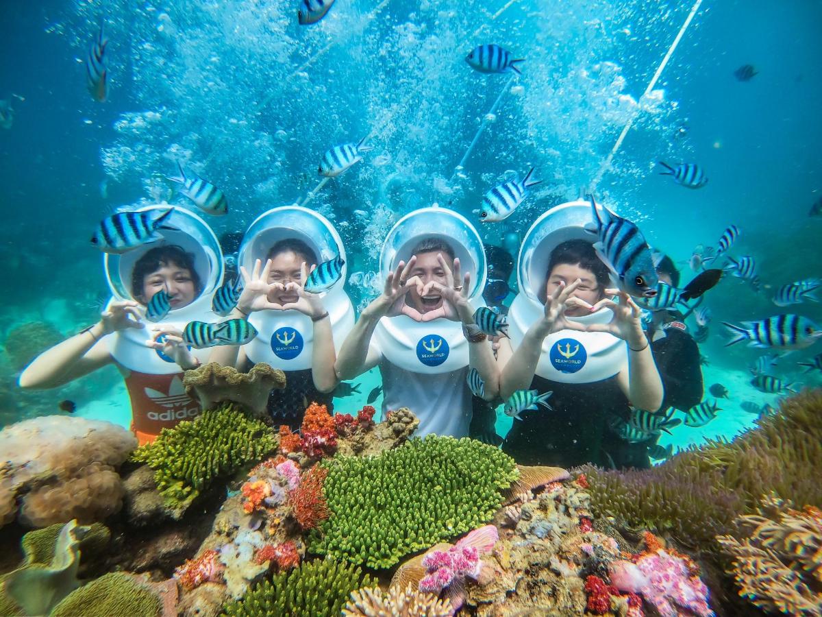 a group of children in the ocean with their hands up