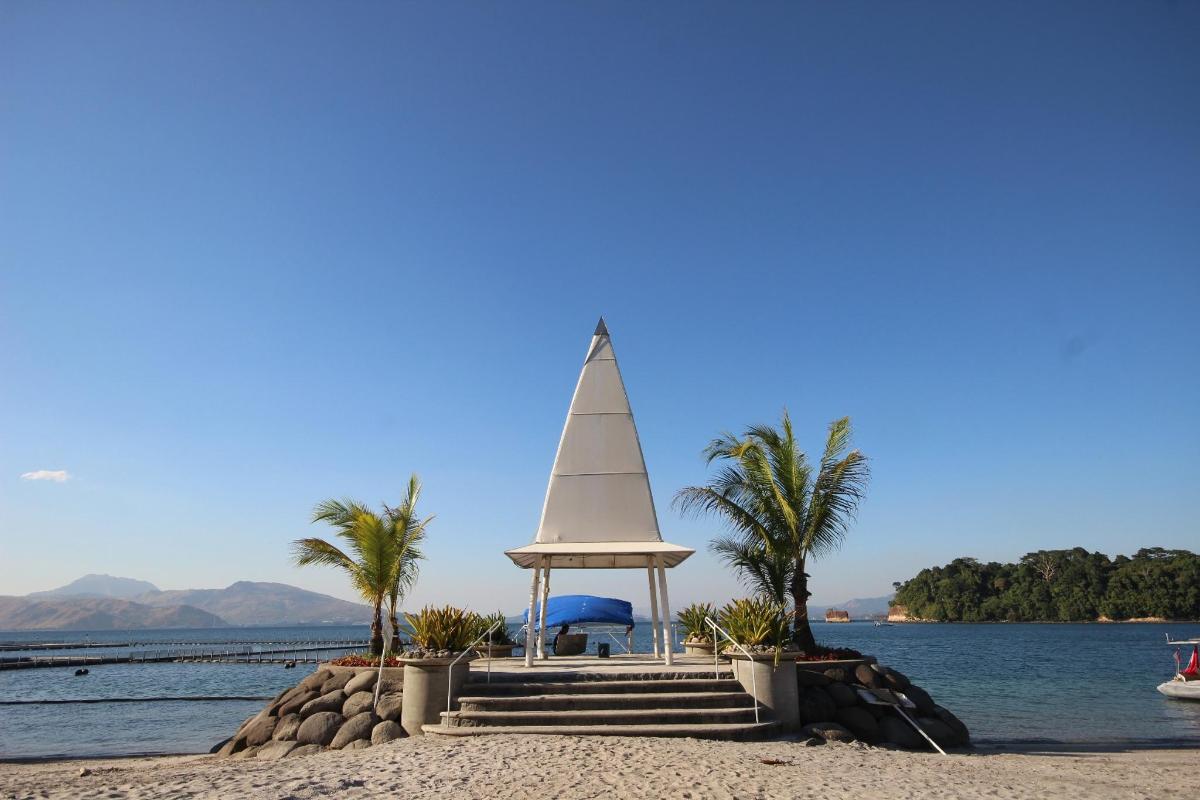 a tower on a beach with palm trees and the water