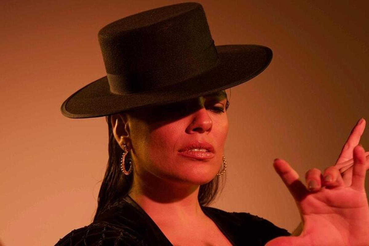 a woman wearing a black top hat with her peace signs