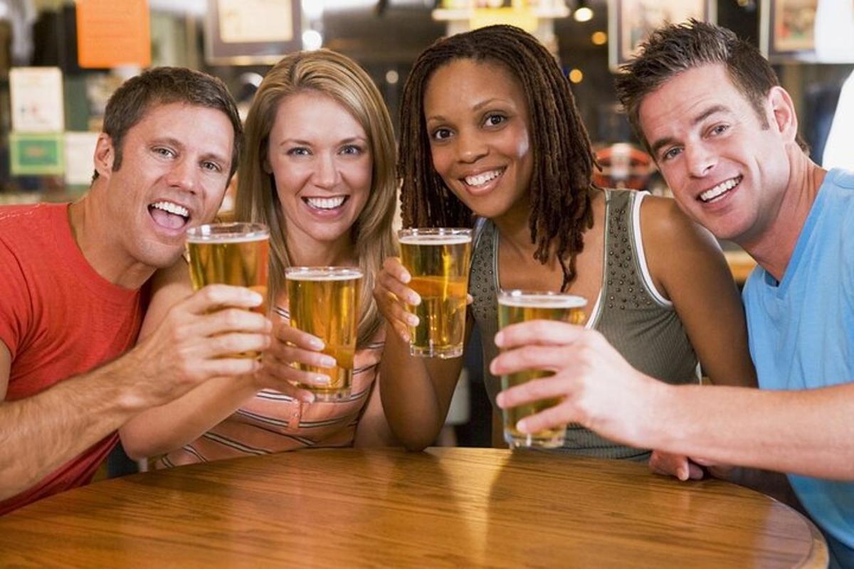 un gruppo di persone sedute a un tavolo a bere birra
