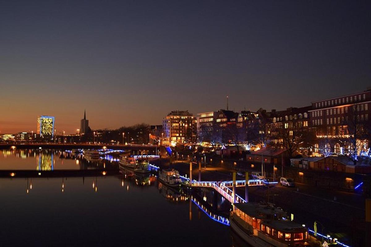 a city lit up at night with boats in the water