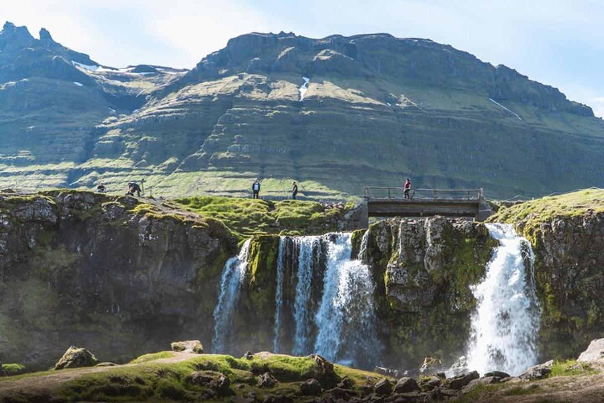 gente parada en un puente sobre una cascada