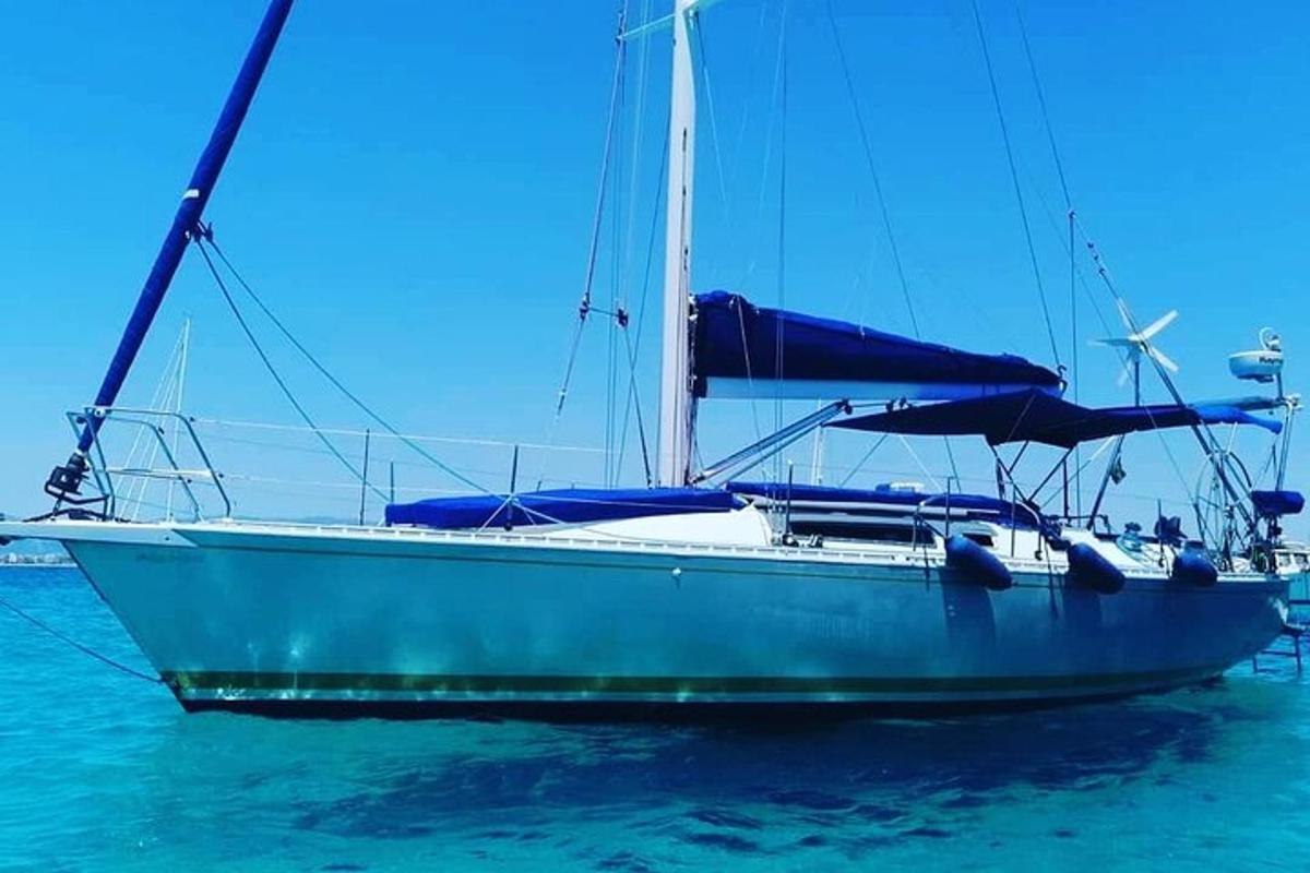 um barco à vela azul sentado na água
