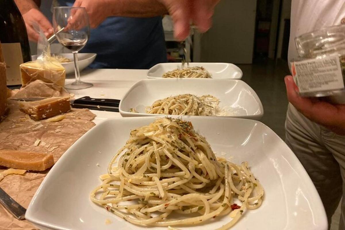 Három tányér spagetti az asztalon egy pohár borral