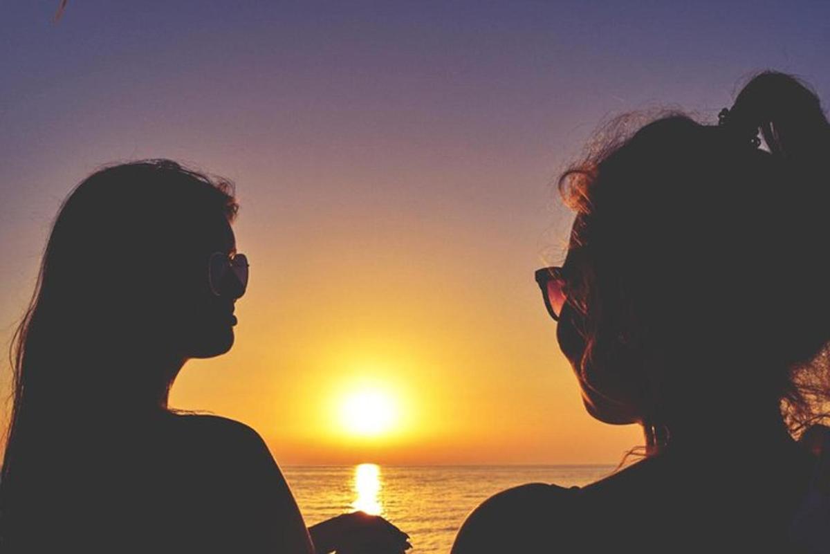 two people watching the sunset on the beach