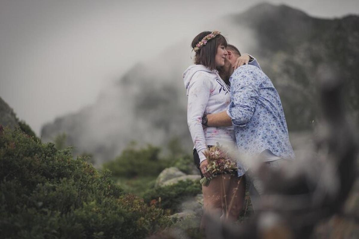 a couple kissing on top of a mountain
