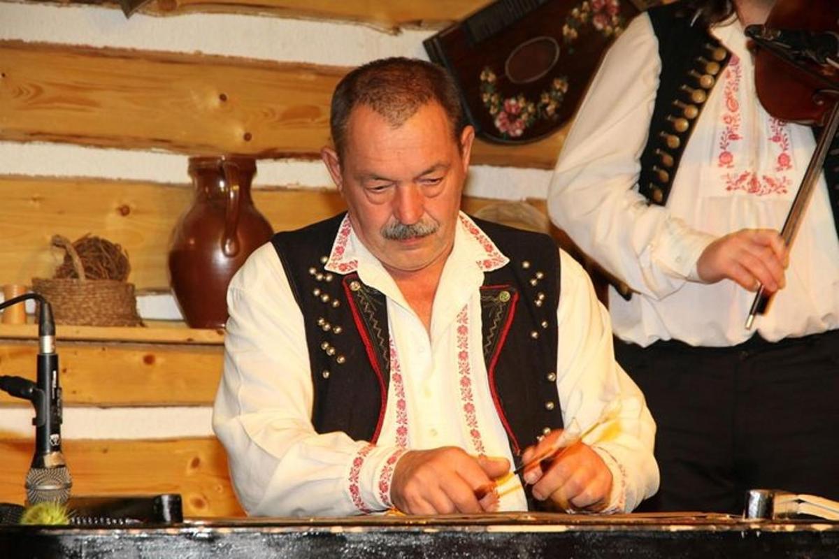 muž sedící u stolu a píšící na kus papíru