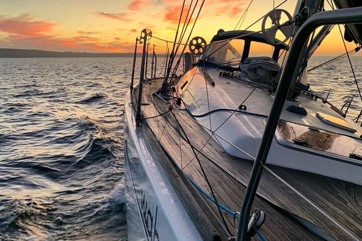 una barca in acqua con un tramonto sullo sfondo