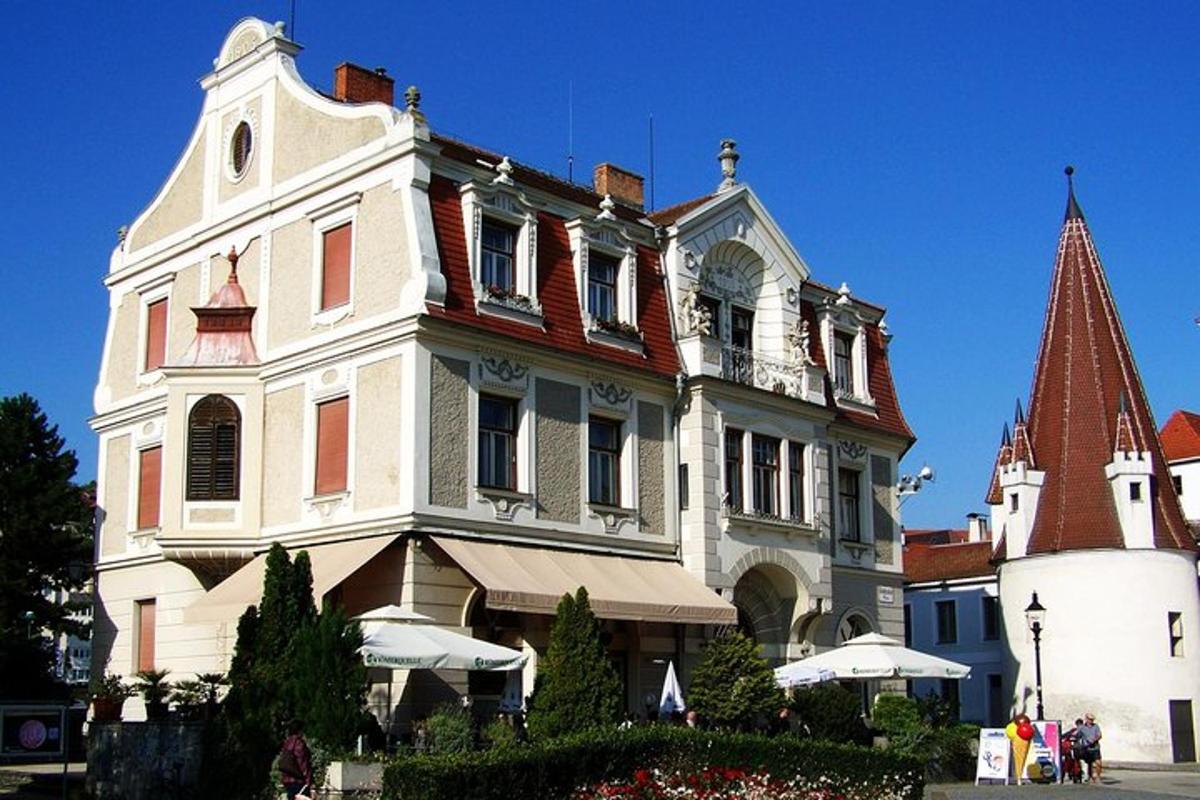 ein großes weißes Haus mit einem Türmchen an einer Straße