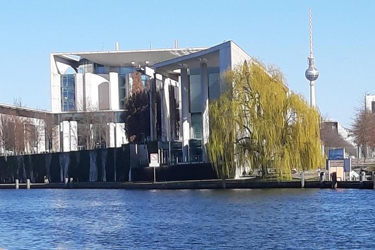 un edificio con un árbol frente al agua