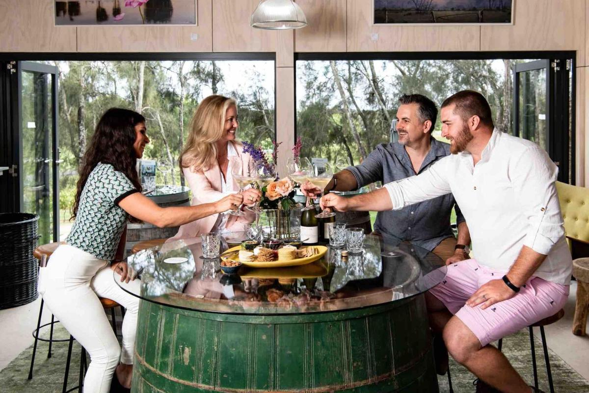 a group of people sitting around a table with wine glasses