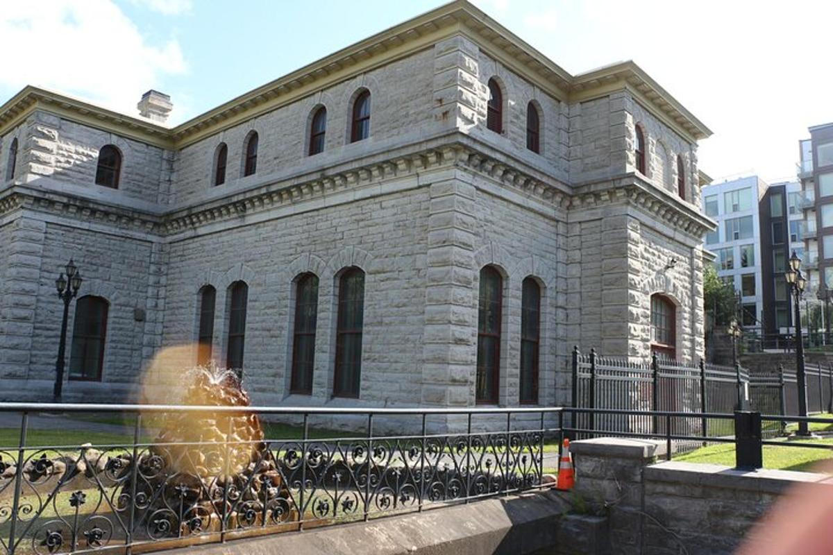 un grande edificio in pietra con una recinzione di fronte