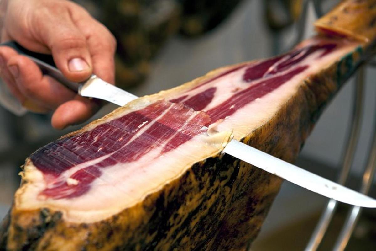una persona cortando un trozo de carne con un cuchillo