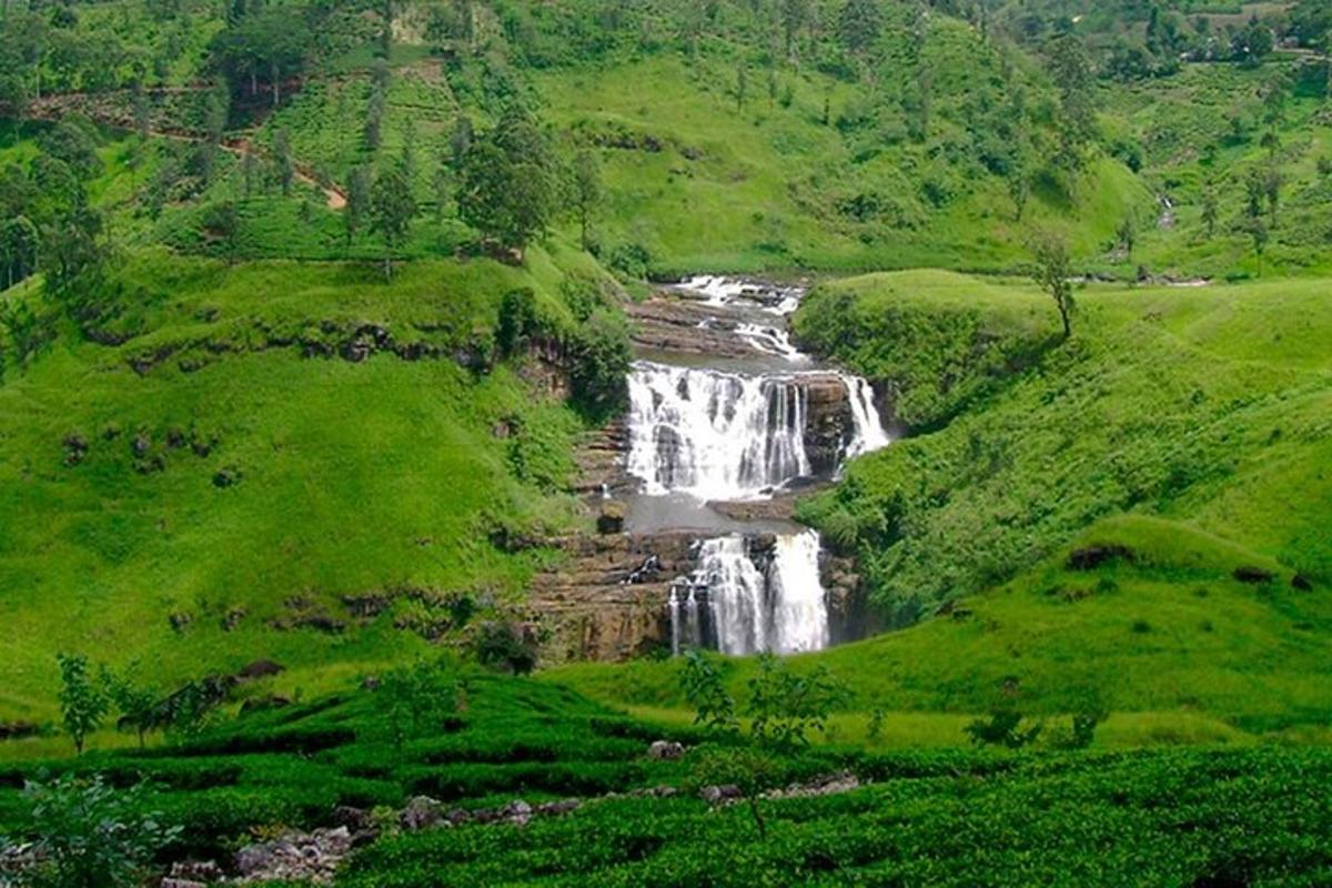 a waterfall in the middle of a lush green valley