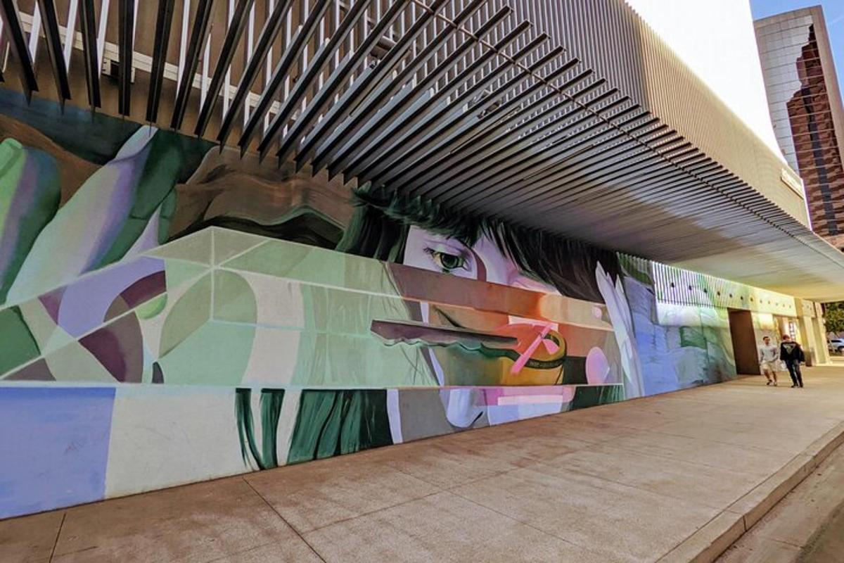 um mural na lateral de um prédio com pessoas caminhando