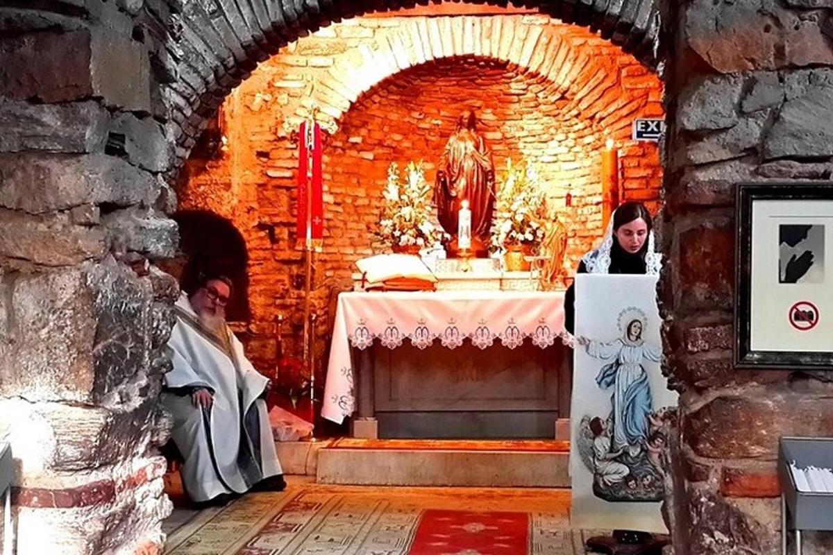 dva kněží sedící v cihlové místnosti se stolem