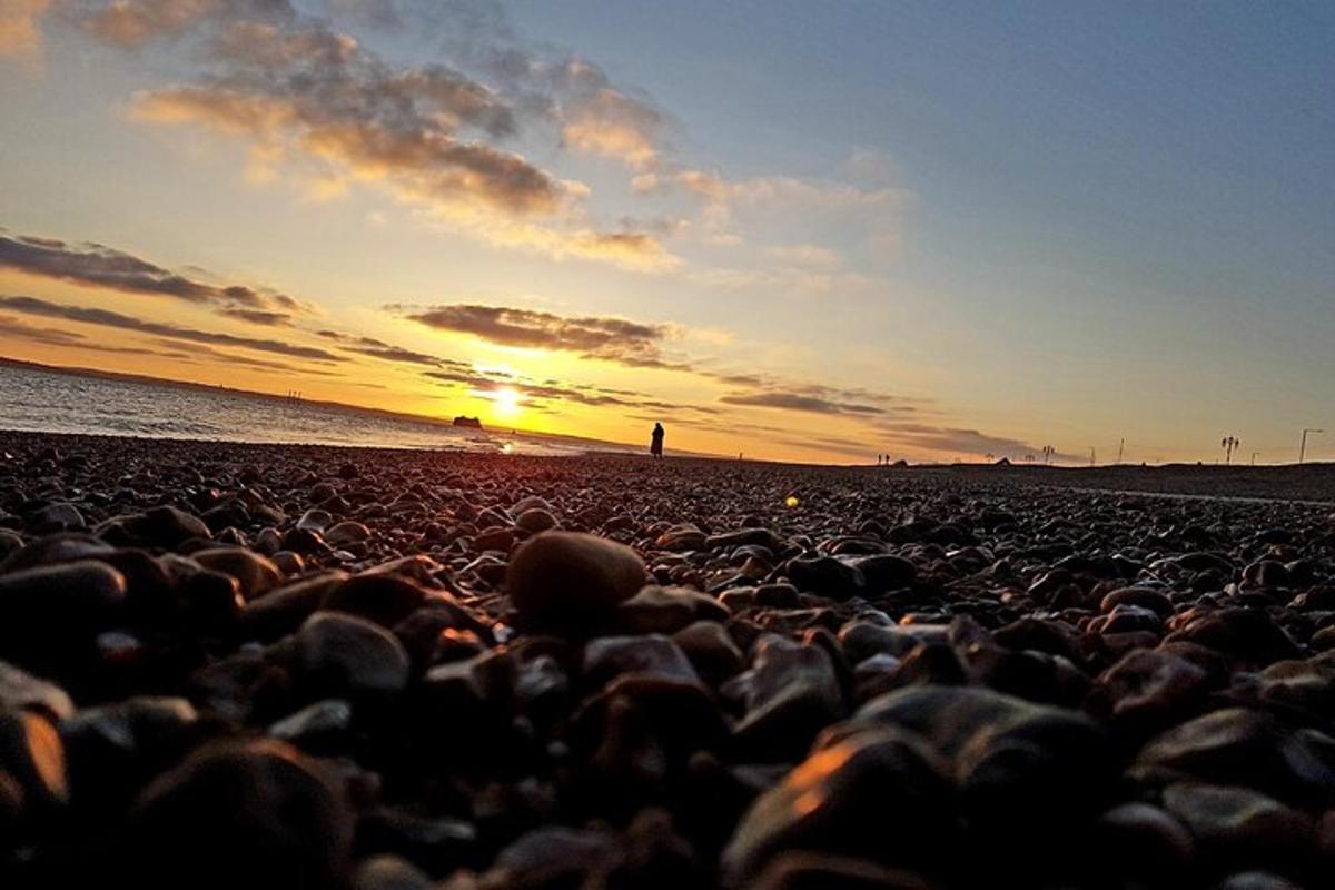 a group of rocks on a beach at sunset