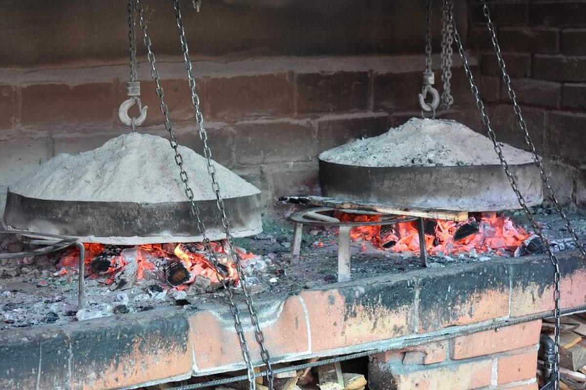 Dos ollas y sartenes colgadas sobre el fuego