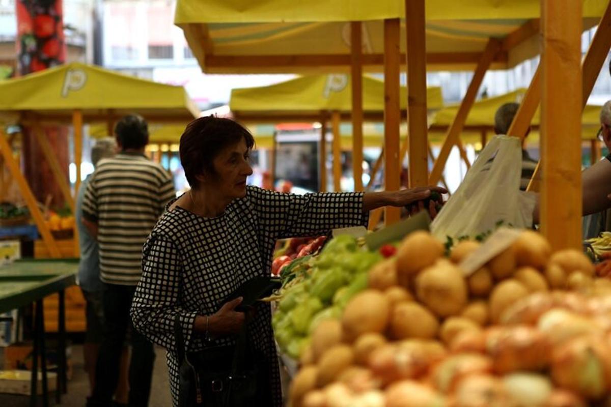 una dona que sosté una bossa de la compra en un mercat
