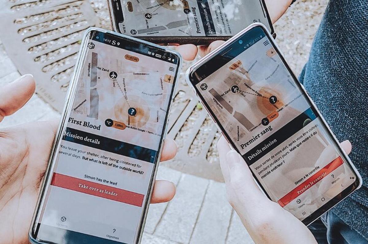 divi cilvēki rokās tur divus mobilos telefonus