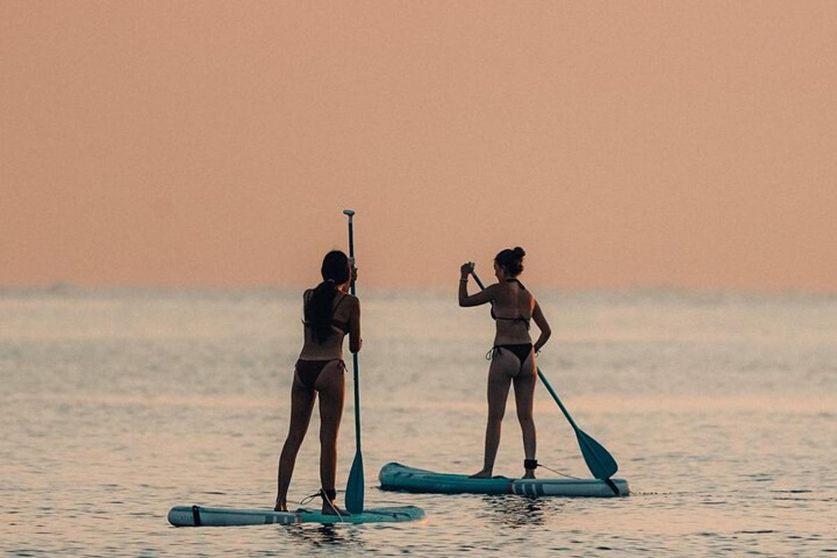 two women in bathing suits on paddle boards in the water