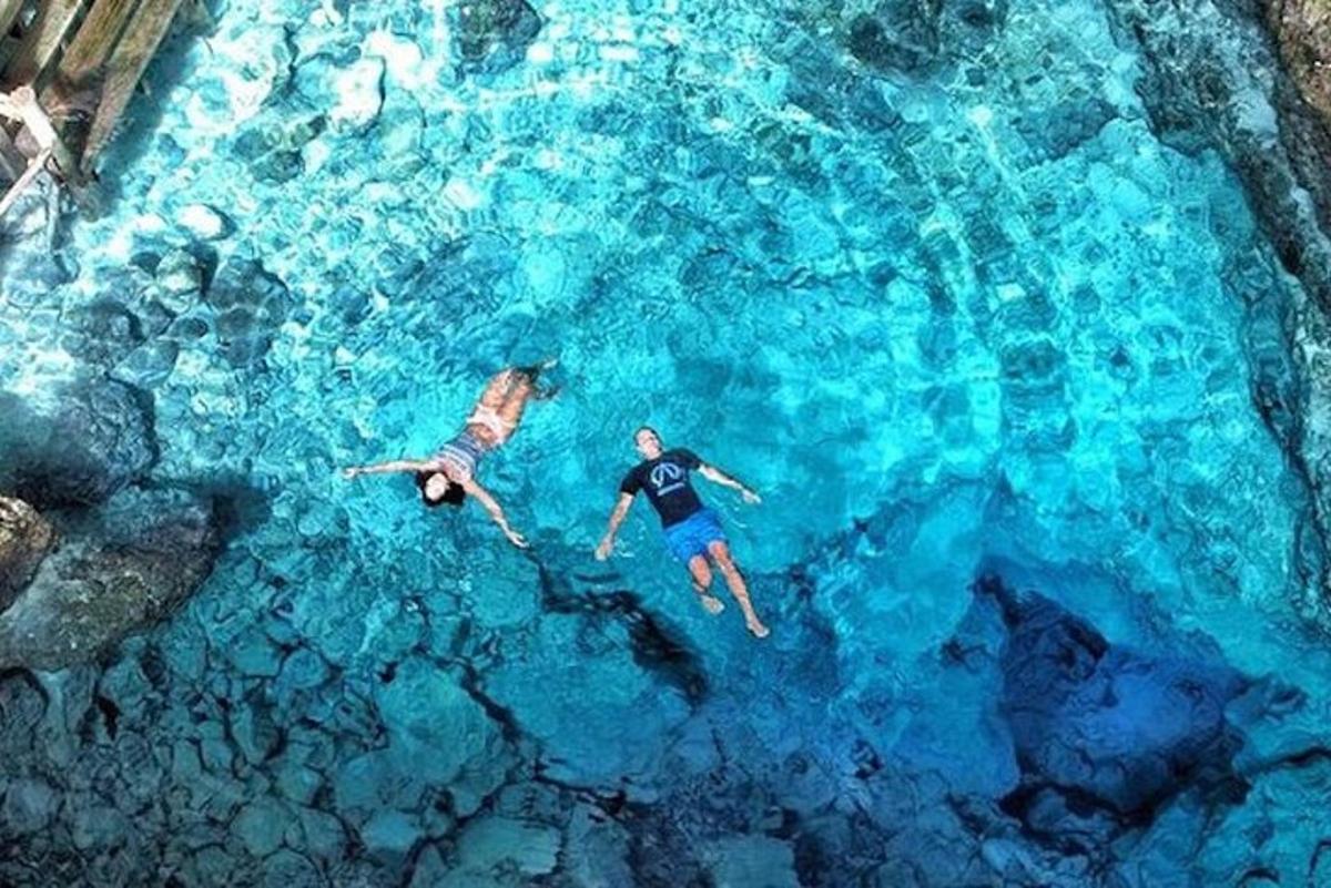 two people are swimming in the blue water