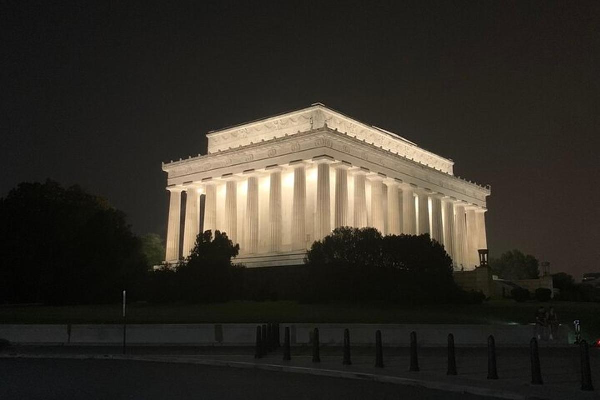 Un gran edificio blanco iluminado por la noche.