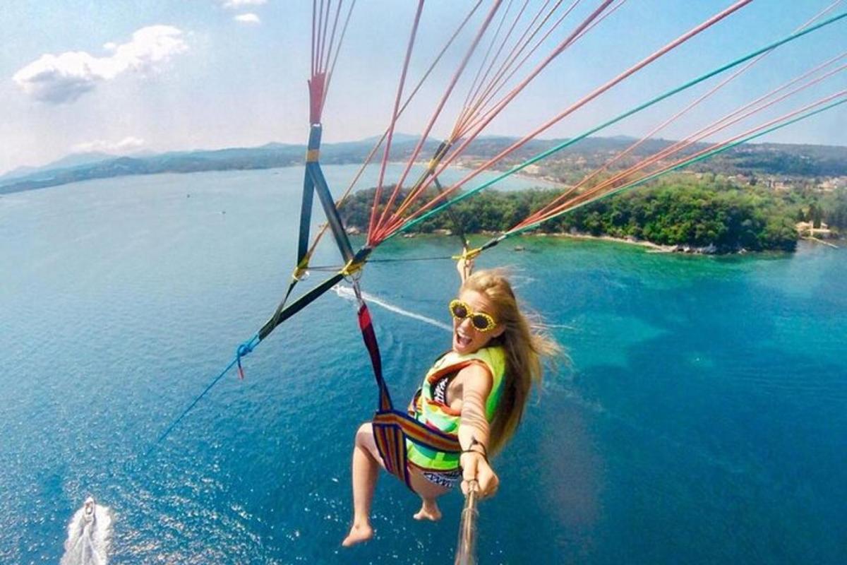 a young girl is riding on a parachute over the water