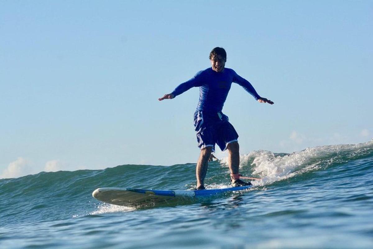 en man som rider på en våg på en surfbräda i havet