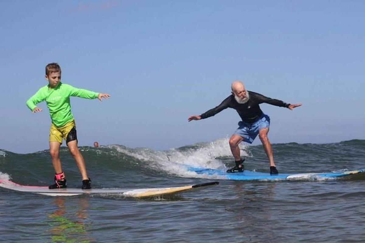 Dos hombres surfeando una ola en tablas de surf en el océano