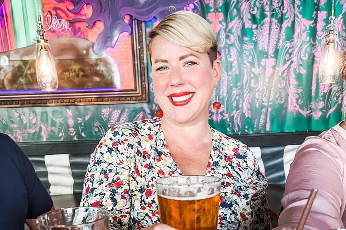 a woman sitting at a table with a glass of beer