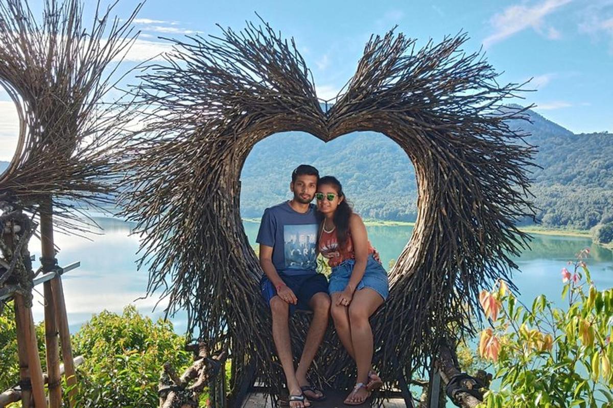 un uomo e una donna seduti in un cuore fatto di erba