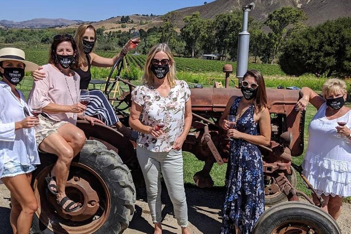 um grupo de mulheres em pé ao lado de um trator