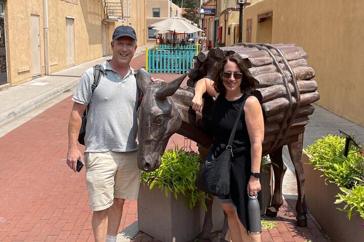 a man and a woman standing next to a statue