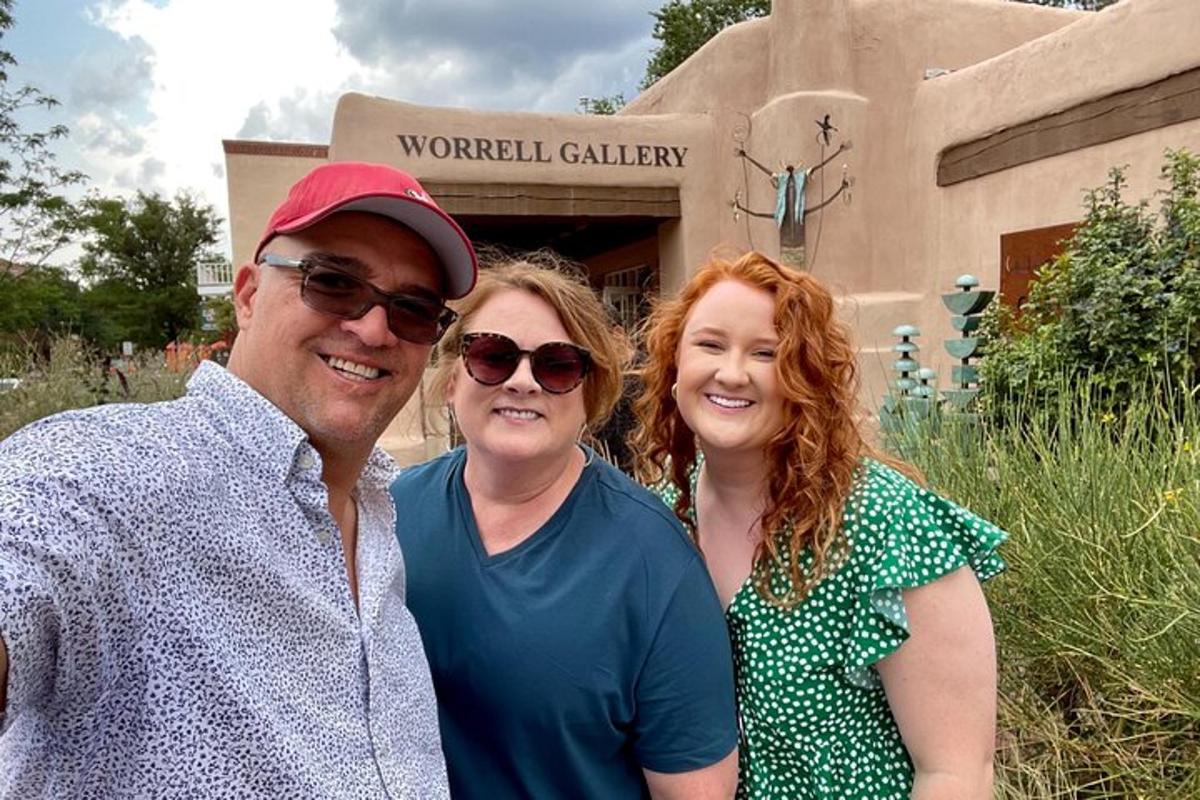 a man and two women standing in front of a building