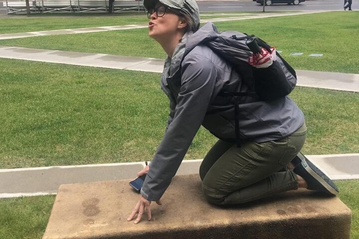 a woman with a backpack sitting on a statue